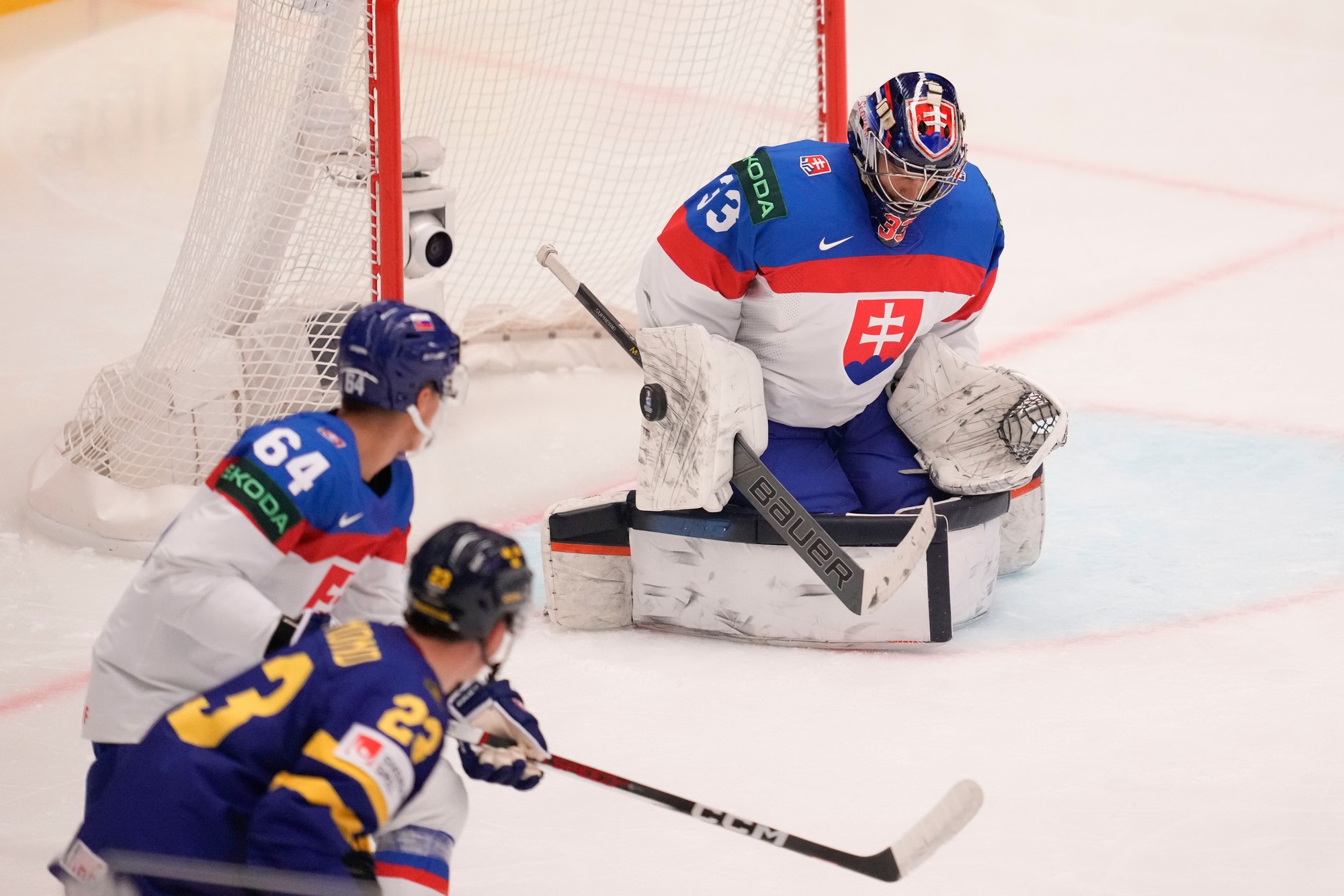 Sprava slovenský brankár Stanislav Škorvánek, jeho spoluhráč Patrik Koch a švédsky hokejista Lucas Raymond.