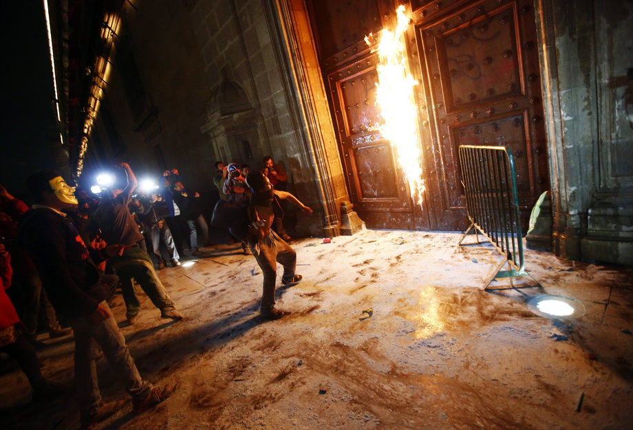A group of protesters set fire to the wooden door of Mexican President Enrique Peña Nieto's ceremonial palace during a protest denouncing the disappearance of 43 Ayotzinapa trainee teachers, in the historic center of Mexico City, November 8, 2014.