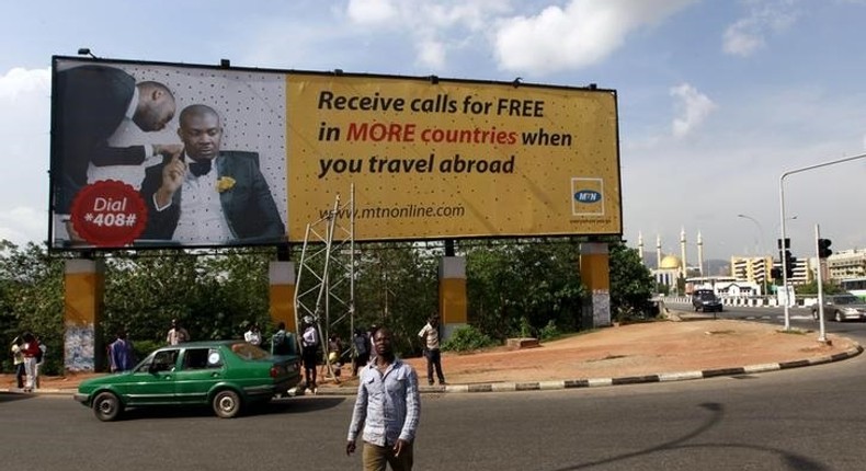 A man walks in front of an advertisement billboard of MTN phone company in Abuja, Nigeria May 25, 2015. 