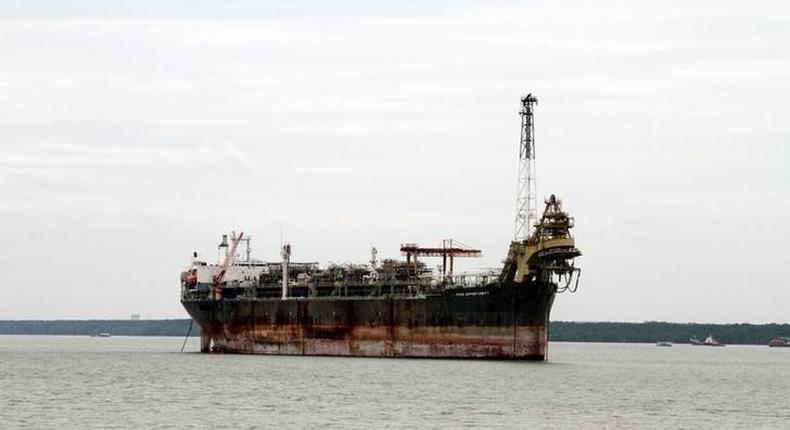 A fishing boat passes in front of the laid-up FPSO Opportunity in the Johor river August 24, 2016. 