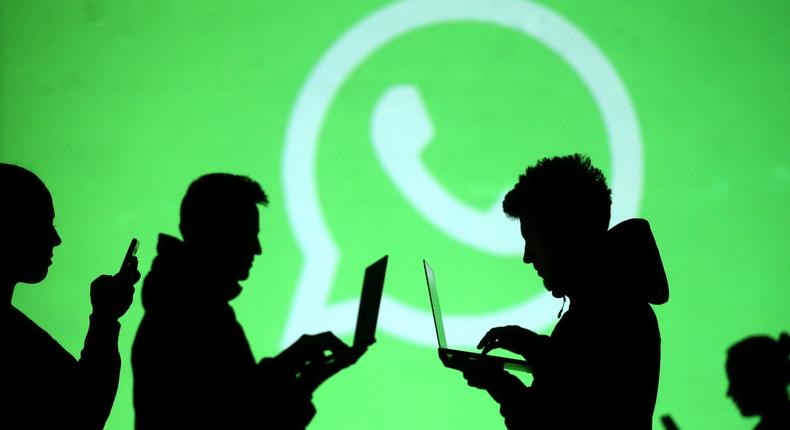 FILE PHOTO: Silhouettes of laptop and mobile device users are seen next to a screen projection of Whatsapp logo in this picture illustration taken March 28, 2018.  REUTERS/Dado Ruvic/Illustration/File Photo