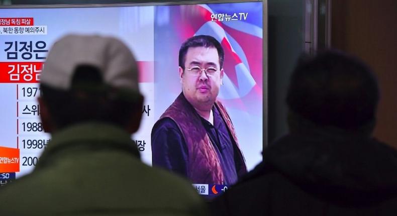 People in a Seoul railway station watch a TV news report on the death of Kim Jong-Nam