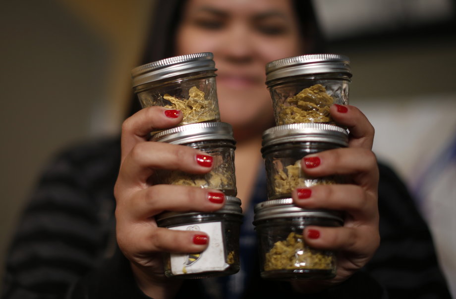 Manager Vanya Lopez, 26, displays jars of cannabis at the La Brea Collective medical marijuana dispensary in Los Angeles, California, March 18, 2014.