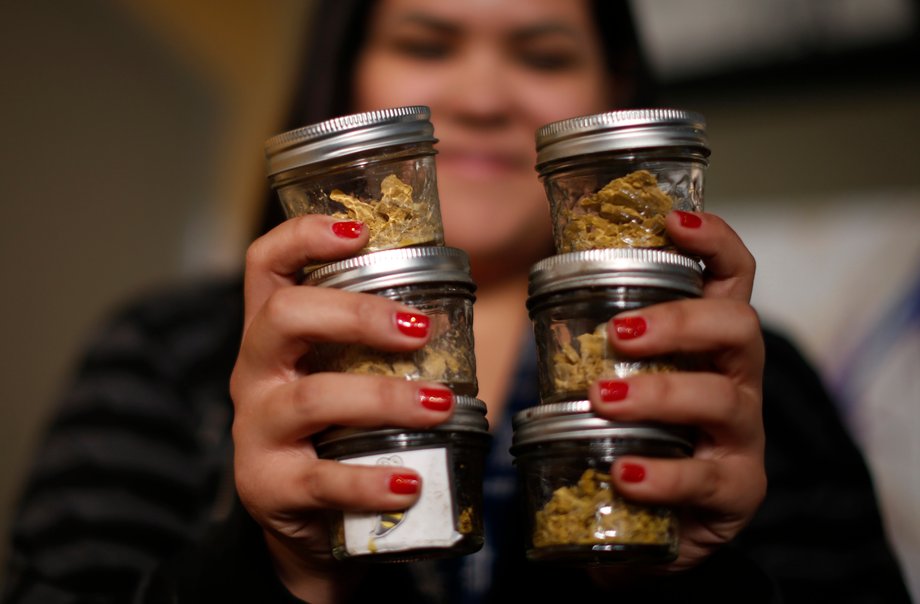 Manager Vanya Lopez, 26, displays jars of cannabis at the La Brea Collective medical marijuana dispensary in Los Angeles, California, March 18, 2014.