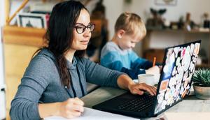 A mom works from home with her son beside her.ilona titova/Getty Images