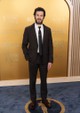 Adam Brody egy elegáns, csokoládébarna Prada öltönyt viselt, amelyhez fekete nyakkendőt és fehér inget párosított. A klasszikus szabásvonal és a mély barna árnyalat kifinomult, mégis modern hatást keltett. Megjelenését barna bőrcipővel egészítette ki, amely harmonizált az öltöny színével, és tökéletes egyensúlyt teremtett a letisztult, visszafogott elegancia és a színész időtlen sármja között.