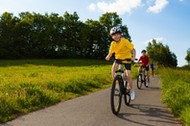 A happy family riding their bikes on a country road