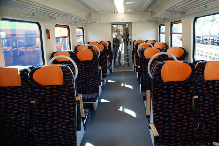 Wewnątrz zmiany są zdecydowanie na lepsze w porównaniu ze starą wersją EN57, która przez pasażerów bywa nazywana „kiblem”. W nowej w środku znajduje się  180 miejsc siedzących. Wagony zostały wyposażone w klimatyzację. Wnętrze pojazdu jest monitorowane przez system 16 kamer. Każdy pojazd został wyposażony w dwie toalety, w tym jedną dostosowaną do potrzeb niepełnosprawnych. Kontrakt jest wart 160 mln zł.