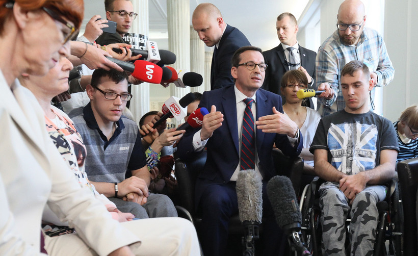 Premier Mateusz Morawiecki (C) i minister rodziny, pracy i polityki społecznej Elżbieta Rafalska (L) spotkali się z uczestnikami stacjonarnego protestu rodziców osób niepełnosprawnych w Sejmie
