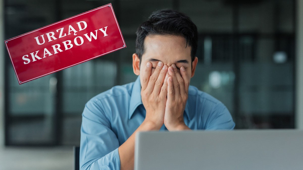 Mężczyzna zakrywa twarz przy laptopie, z boku tablica informacyjna z napisem urząd skarbowy