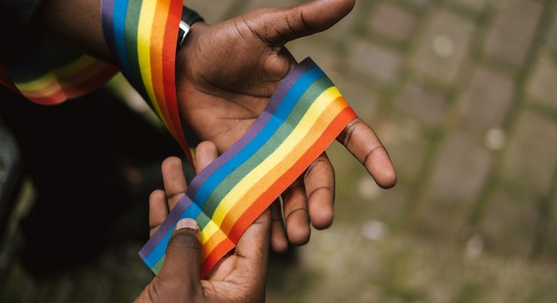 Man showing LGBTQIA ribbon on hand [Photo: Anete Lusina]