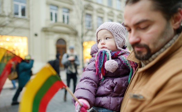 Ojciec z dzieckiem, które trzyma litewską flagę