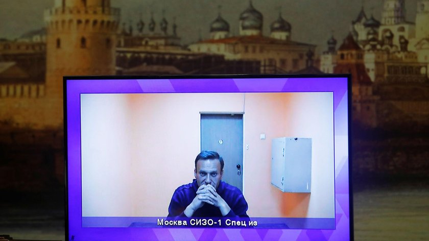 Russian opposition leader Alexei Navalny is seen on a screen via a video link during a court hearing