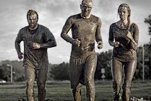 group of people jogging in mud