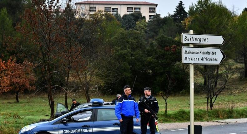 French police stand guard on a road near a retirement home for Christian missionaries in Montferrier-sur-Lez, southern France, on November 25, 2016