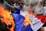 Muzułmanie palą francuską flagę w proteście przeciwko publikacji karykatur Mahometa, Peszawar, Pakistan, październik 2020 r.