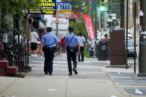 Philadelphia Police officers patrol a street.