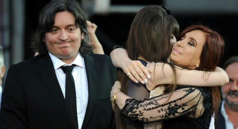 Argentina's then-President Cristina Kirchner (R) is embraced by her daughter Florencia next to her son Maximo, who went before a judge over their roles in the family's real estate company, during her inauguration ceremony in 2011