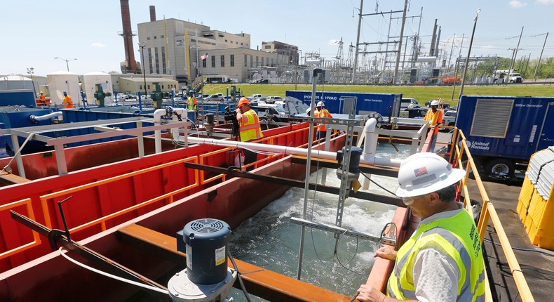 Workers look over wastewater from coal ash as it is aerated in a treatment facility outside Dominion Powers Bremo Bluff power plant in Bremo Bluff, Va., Tuesday, April 26, 2016.
