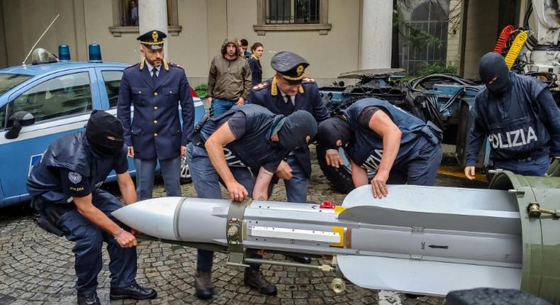 This handout picture released by the Italian police (Polizia di Stato) of Turin, on July 15, 2019, shows italian policemen carry an air-to-air missile, as part of a big cache of guns and ammunition that was seized by the Turin special police force, called Digos, led the operations, assisted by police in Milan, Varese, Forli and Novara.Anti-terrorism police in northern Italy have seized an air-to-air missile and other sophisticated weapons during raids on far-right extremist groups