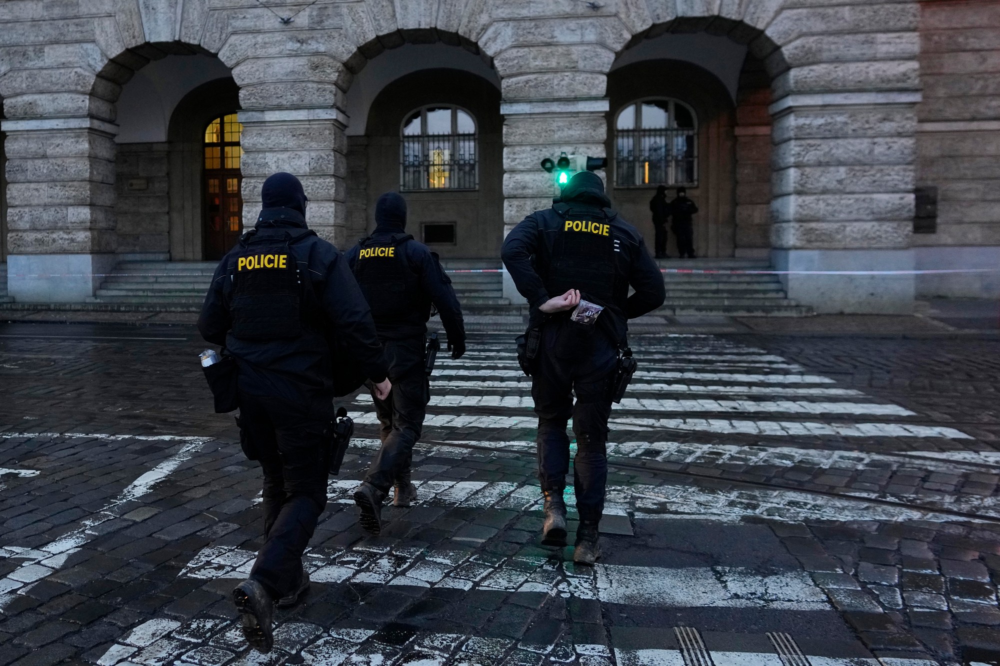 Policajti kráčajú pred budovou Filozofickej fakulty Univerzity Karlovej (FF UK) po streľbe v centre Prahy.