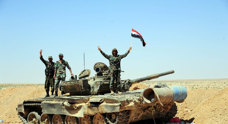 Forces loyal to Syrian President Bashar Assad on a tank in the southeast Syrian desert, June 13, 2017.