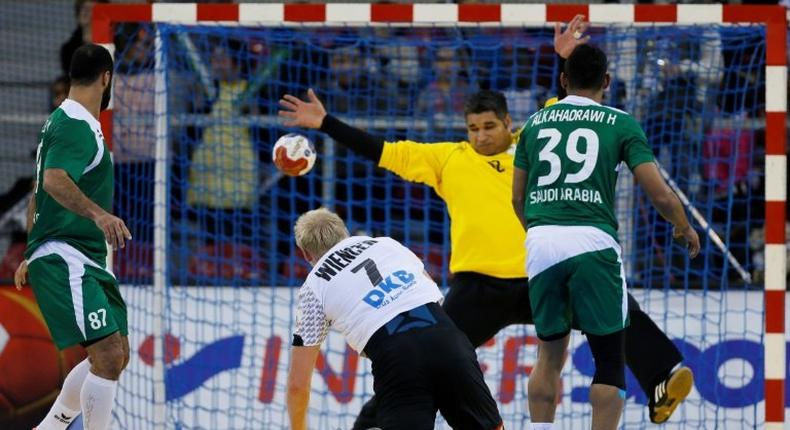 Germany's pivot Patrick Wiencek (Bottom) shoots against Saudi Arabia's goalkeeper Manaf Alsaeed during the 25th IHF Men's World Championship 2017 Group C handball match Germany vs Saudi Arabia on January 17, 2017 at the Kindarena in Rouen