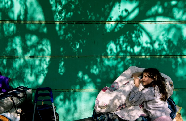 Wenezuelska dziewczynka czeka pod konsulatem w Santiago, Chile. Skrajne ubóstwo motywuje Wenezuelczyków do powrotu do ogarniętej pandemii ojczyzny.  Fot. East News