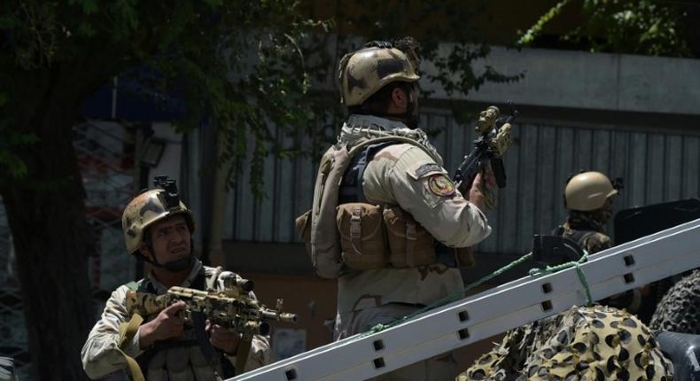 Afghan security forces stand guard at the site of a suicide blast near Iraq's embassy in Kabul