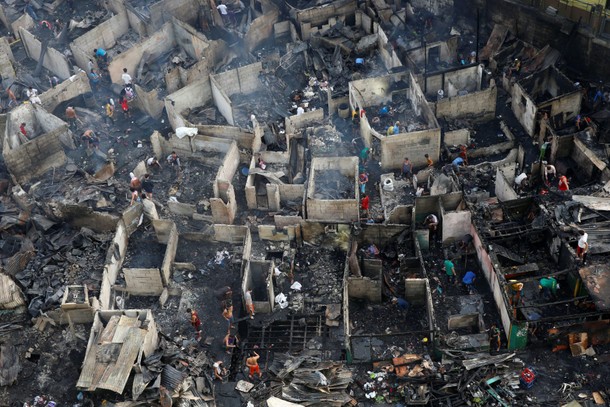 Residents sift through the ruins of their houses after a fire razed a squatter colony, in Quezon cit