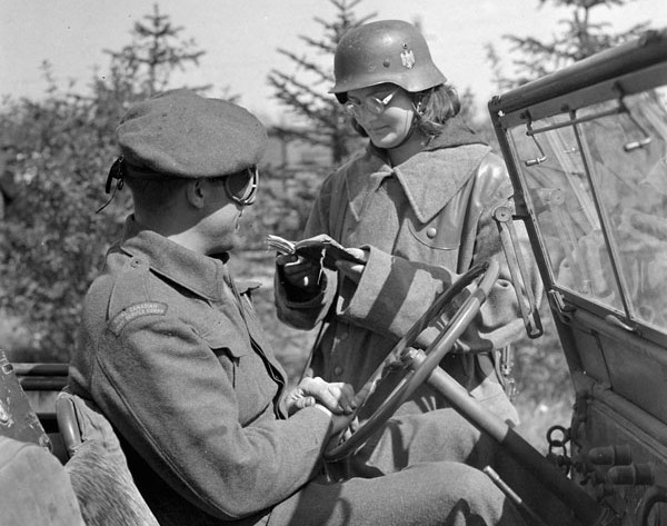 Polka w mundurze niemieckim sprawdza dokumenty przy głównej bramie obozu w Haren po jego wyzwoleniu, 7 maja 1945 r.