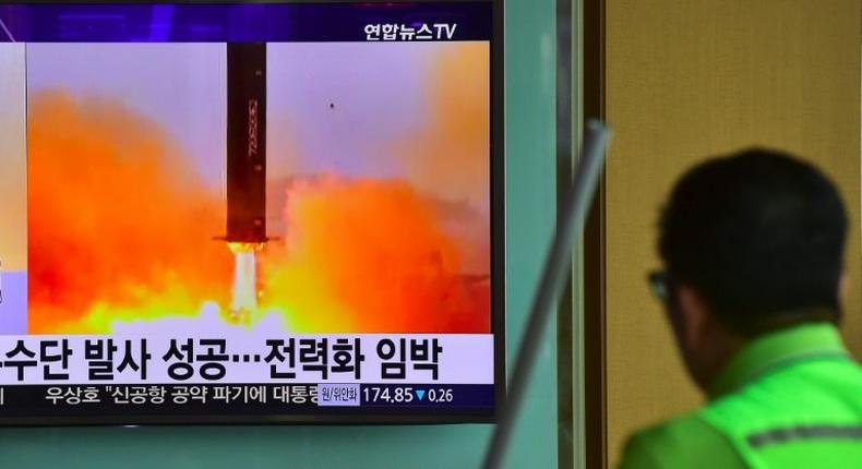 A man walks past a television screen reporting news of North Korea's Musudan missile test in June 2016