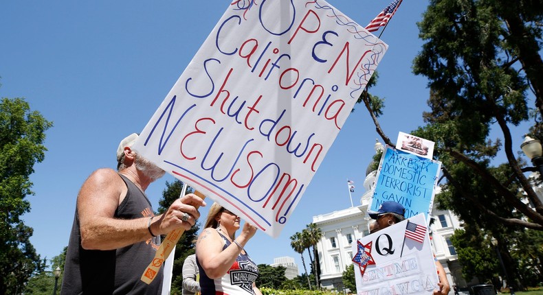 FILE - In this May 1, 2020, file photo protesters calling for the end of Gov Gavin Newsom's stay-at-home orders march around the state Capitol in Sacramento, Calif.  More Americans disapprove than approve of protests that have taken place across the country against restrictions put in place to prevent the spread of COVID-19, according to a new poll by The University of Chicago Divinity School and The Associated Press-NORC Center for Public Affairs Research. (AP Photo/Rich Pedroncelli, File)