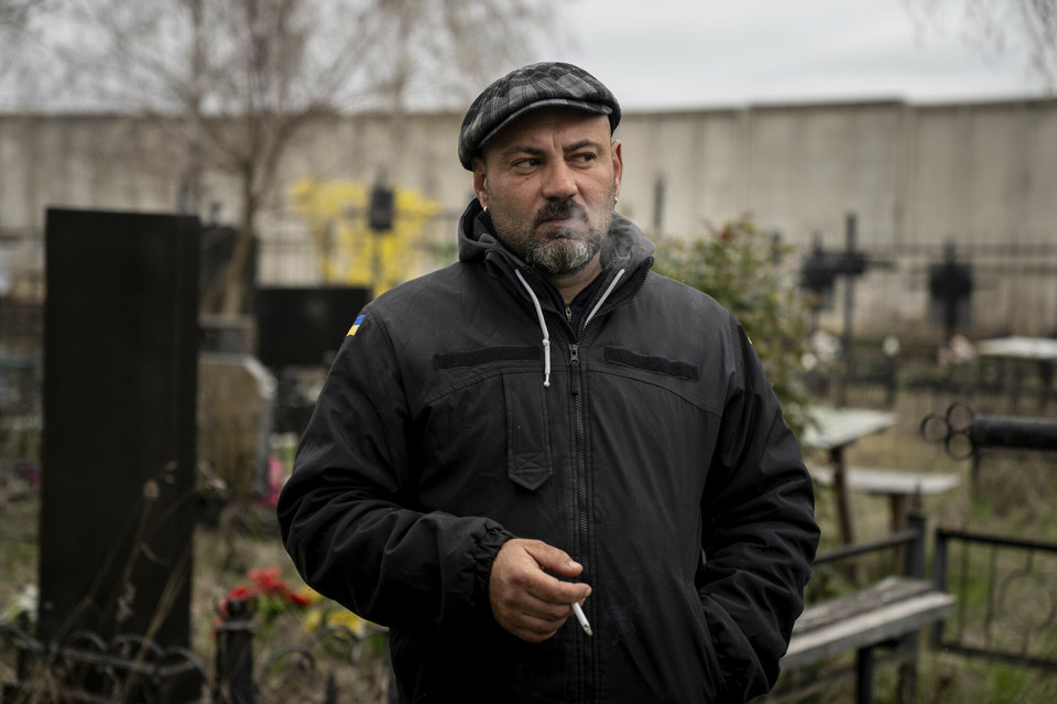 Wład Minczenko pali papierosa na cmentarzu w Buczy