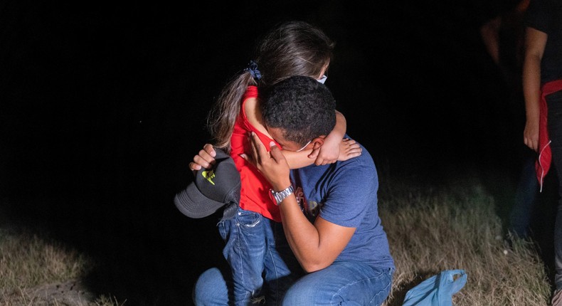 An immigrant father and daughter embrace after crossing the border from Mexico on August 13, 2021 in Roma, Texas.
