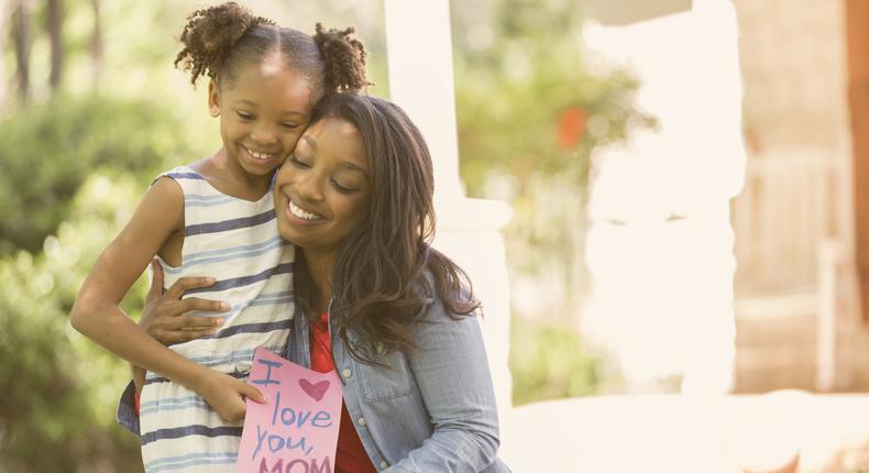 Happy Mother's Day Girl gives card to mother
