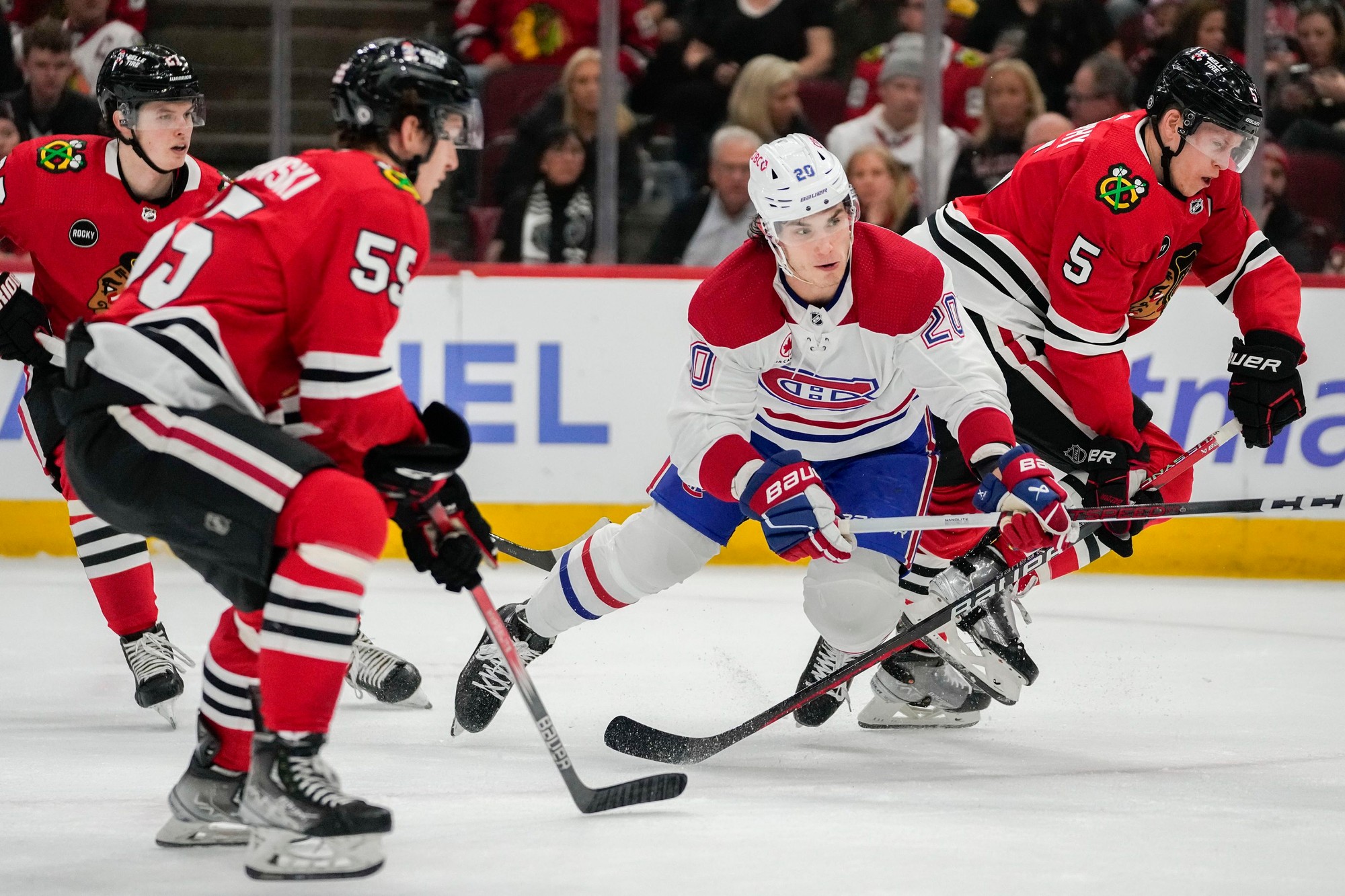 Juraj Slafkovský (Montreal Canadiens) v súboji s hráči Chicago Blackhawks.