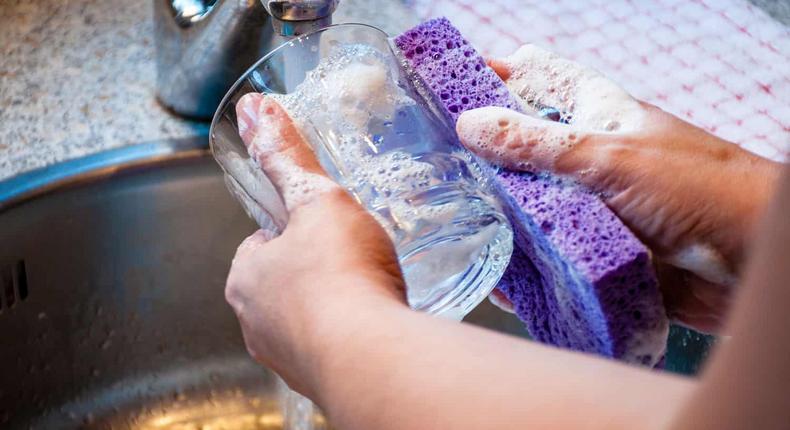 Woman hand washing a drinking glass