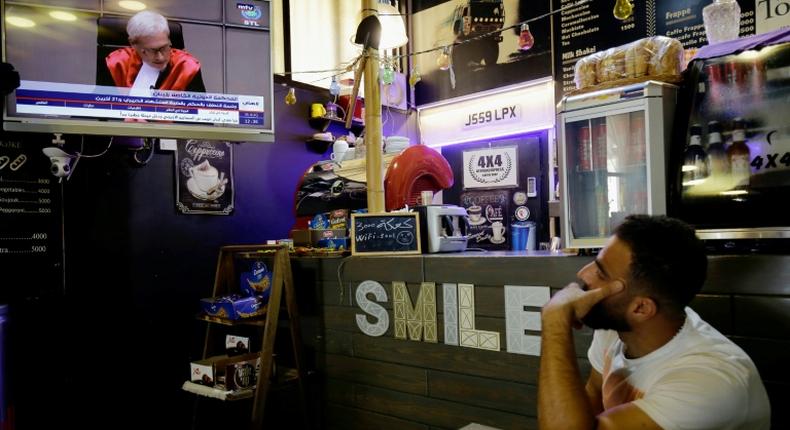 A Lebanese man watches the final verdict session of the Special Tribunal for Lebanon (STL) on former premier Rafic Hariri's assassination in 2005 at a coffee shop in the northern port city of Tripoli