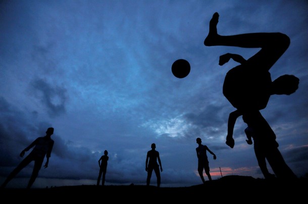 A boy kicks a ball as he plays soccer with his friends at Galle Dutch Fort in Galle