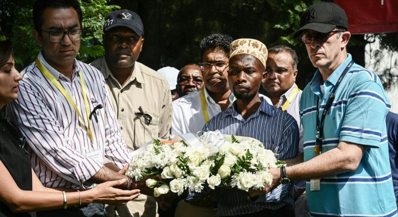 DusitD2 hotel General Manager Michael Metaxas (R), a survivor, placed a wreath with other staff at the gate of the complex in Nairobi where 21 people were killed