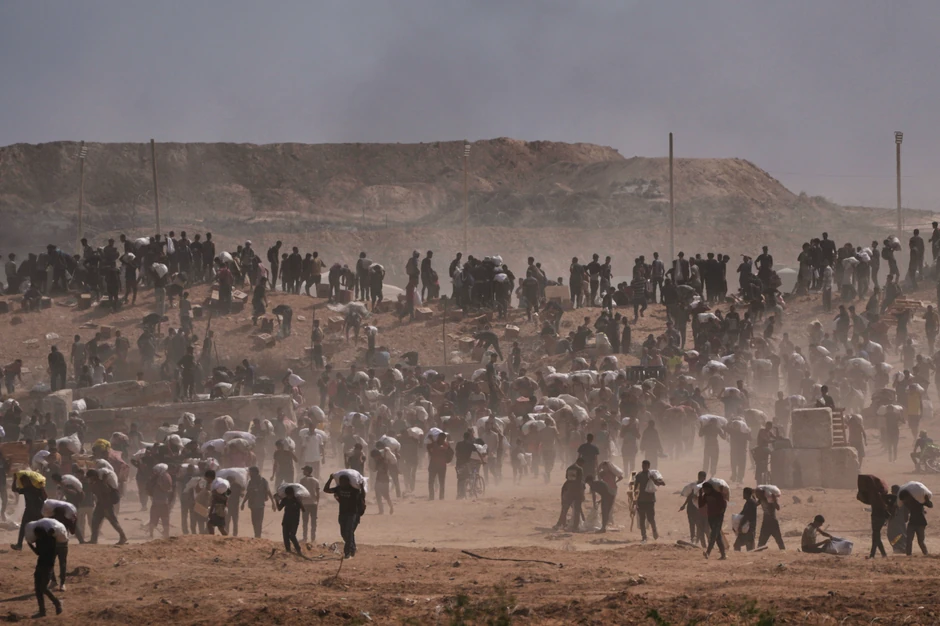 Palestinci nose humanitarnu pomoć blizu centra FHF u Necarimu u centralnoj Gazi 4. avgusta