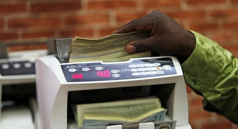 A bureau de change operator counts U.S. currency notes in Abuja, March 12, 2015. 
