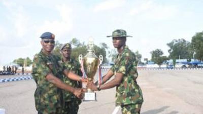 The Chief of Policy and Plans NAF Headquarters, AVM Soya Olatunde , presenting Trophy to Mi35 Champion Squadron, during the beating of the retreat of Basic Military Training Course 43/202 on Thursday in Kaduna