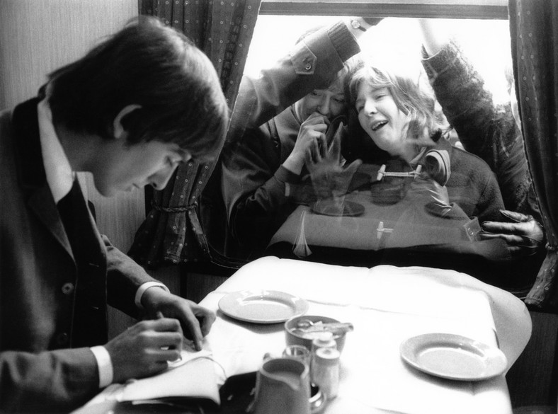 Fanki wyglądające George'a Harrison przez okno pociągu [1964]