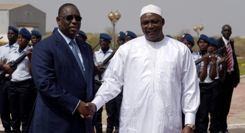 Senegalese president Macky Sall (L) shakes hands with his Gambian counterpart Adama Barrow upon his arrival at Dakar airport for a three-day official visit to Senegal, on March 2, 2017