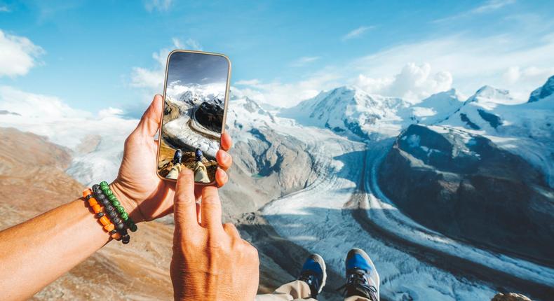 A stock image shows a tourist photographing the Gorner Glacier in Switzerland.Roberto Moiola / Sysaworld via Getty Images