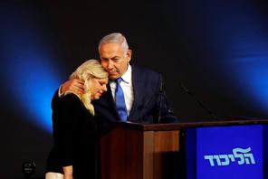 Israeli Prime Minister Benjamin Netanyahu hugs his wife Sara as they stand on stage following the an