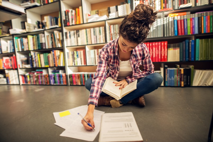 młoda kobieta w bibliotece, studentka, uczennica, nauka, książki,