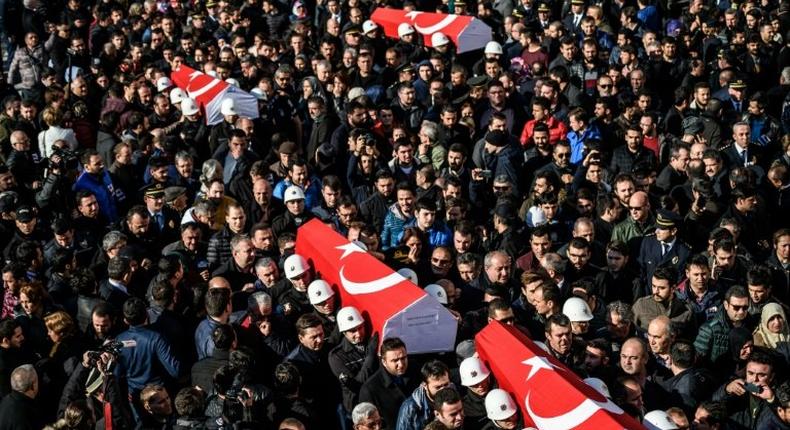 Turkish police officers carry the coffins of comrades killed in bomb attacks during a funeral cerenomy at Istanbul's police headquarters on December 11, 2016